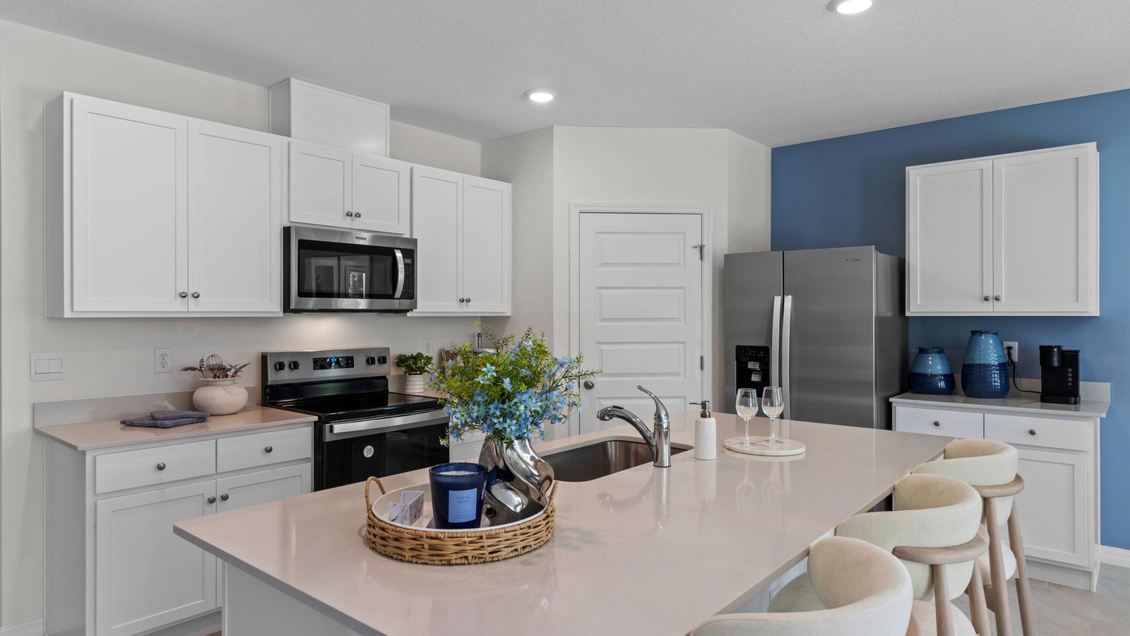 Open kitchen area with barstools and stainless steel appliances