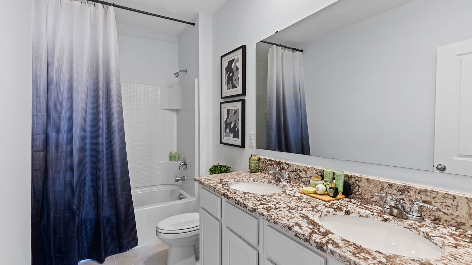 Upstairs guest bathroom with double vanity sinks and tub