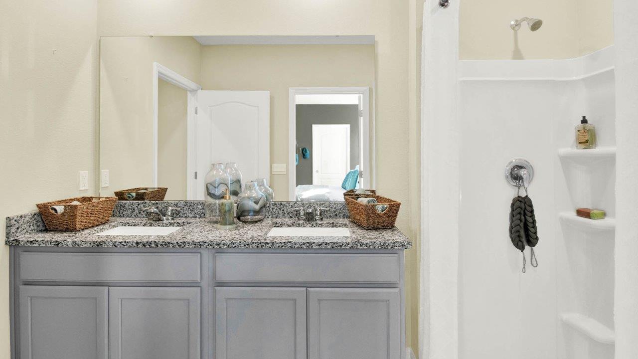 Primary bathroom with double vanity sink and walk in shower