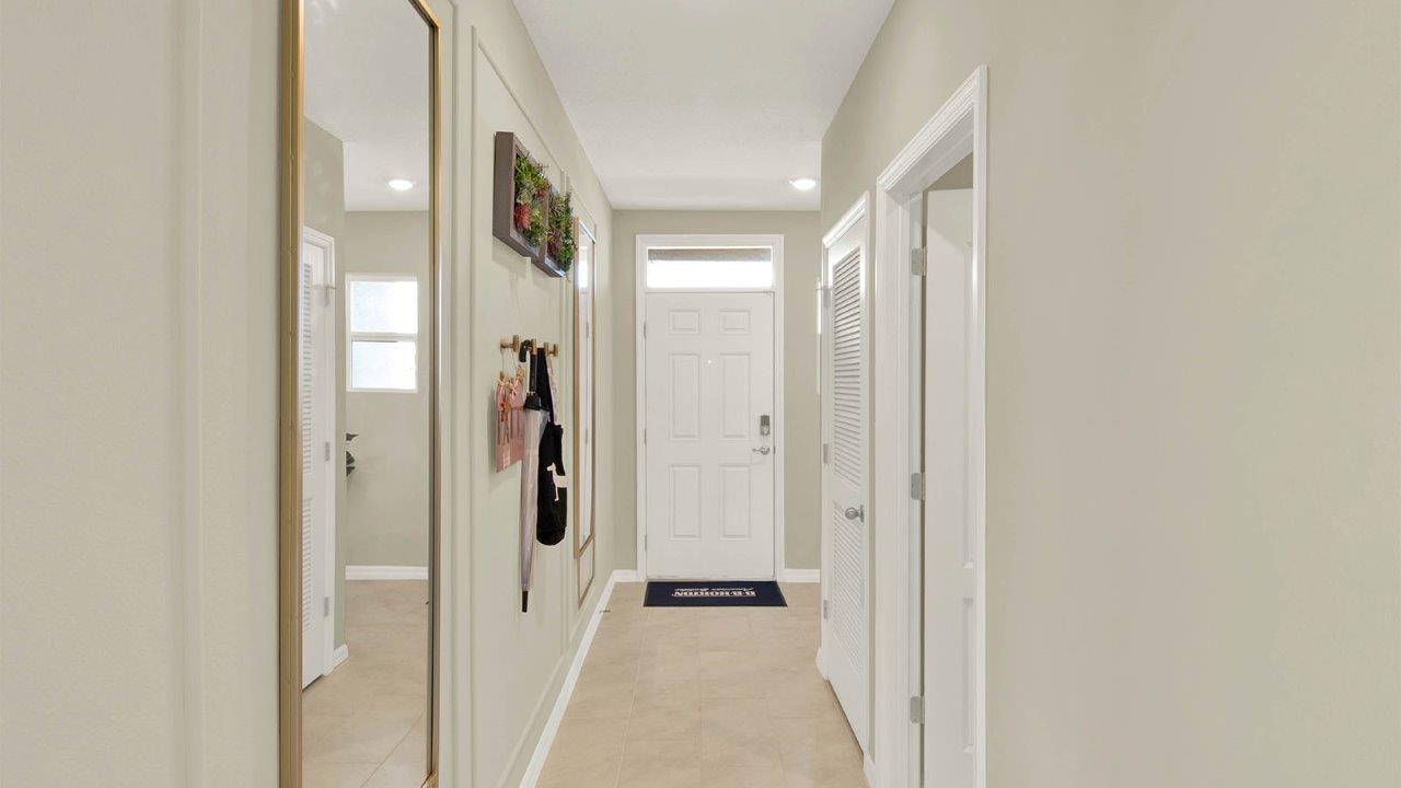 hallway leading to the front door with a door to the laundry room
