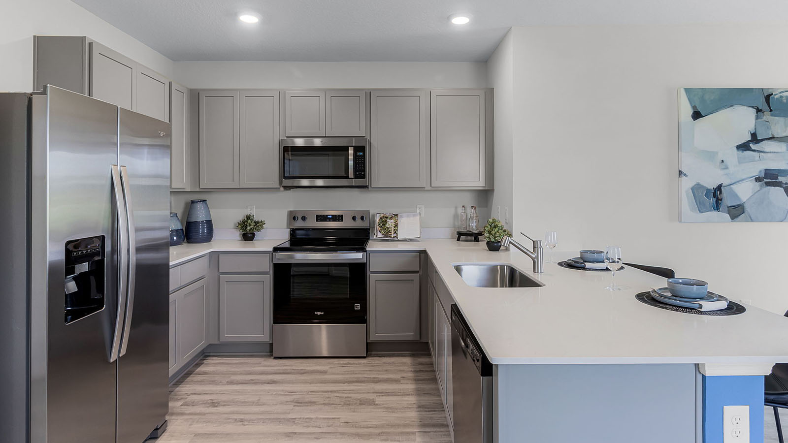 Kitchen with stainless steel appliance and luxury vinyl planks