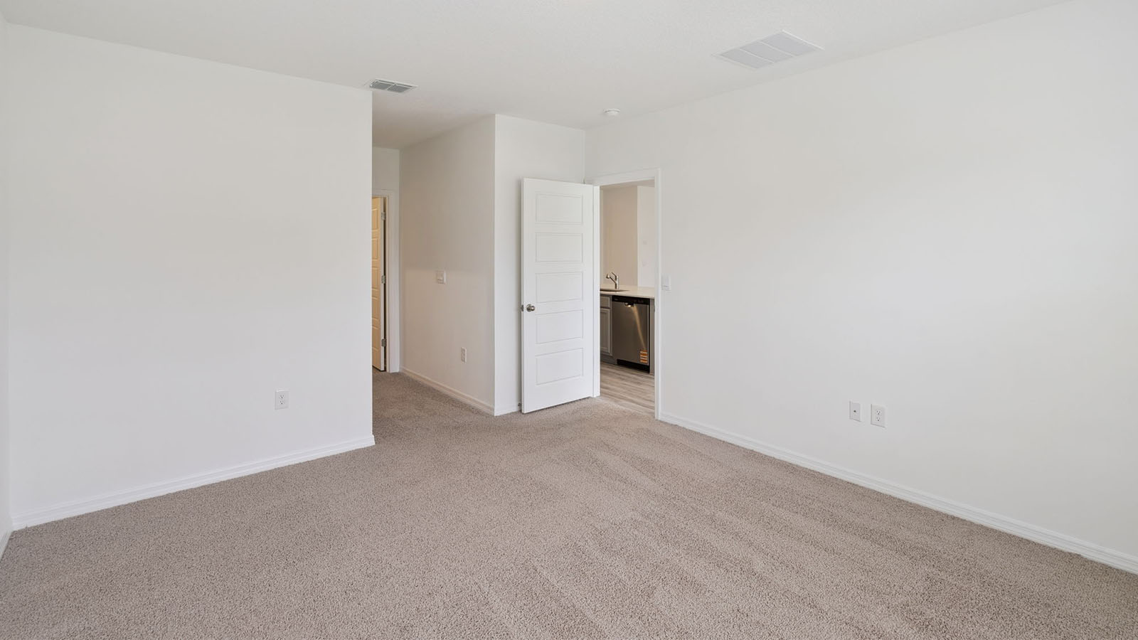 Primary Bedroom located off kitchen with carpet