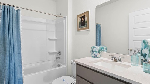 Guest bathroom with quartz countertops and tub