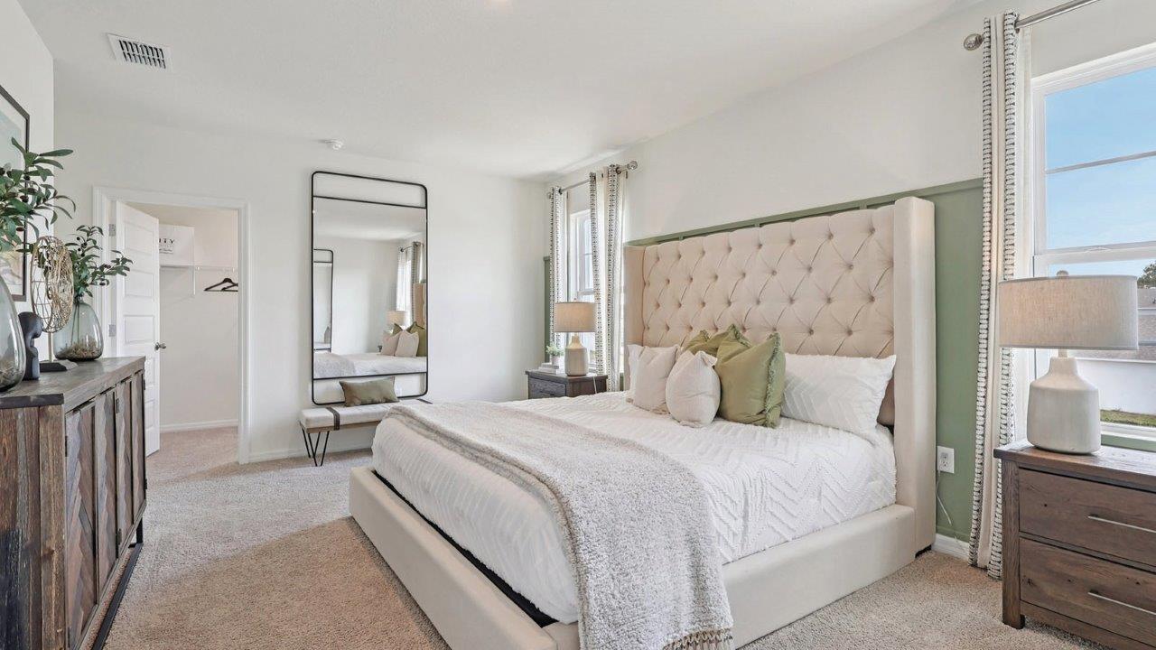 Primary bedroom with king sized bed, two nightstands and dresser