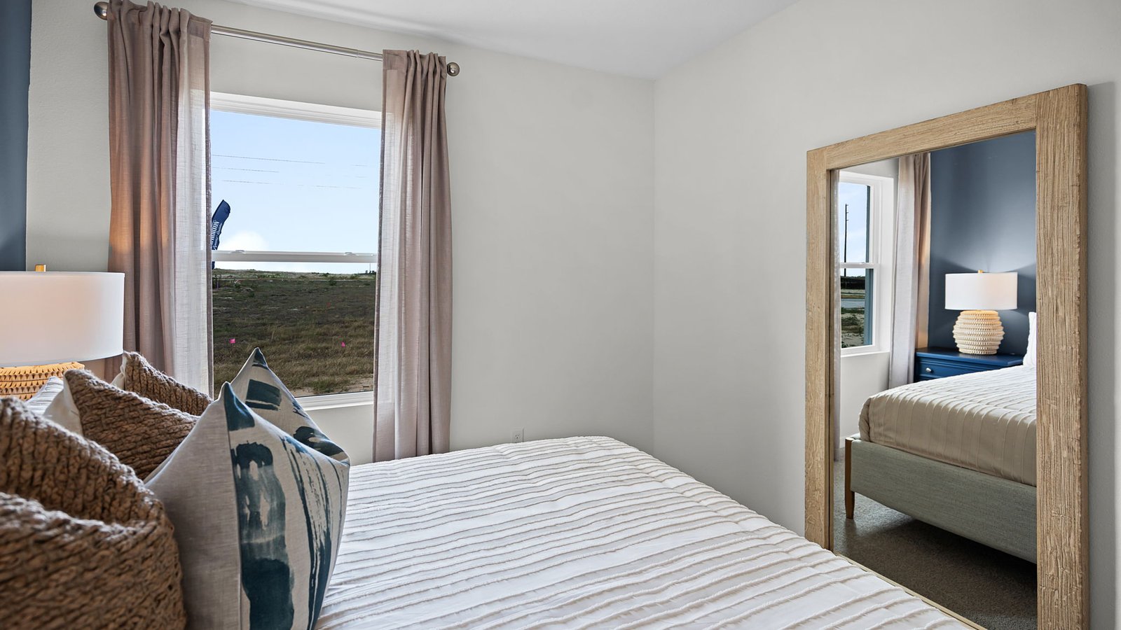 Guest bedroom with queen size bed, window and mirror