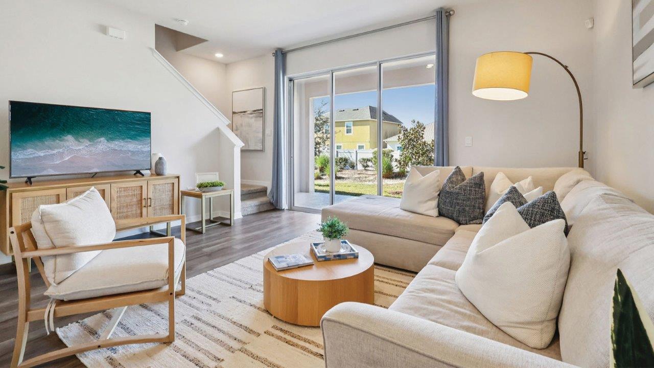 Living room with couch, tv and oversized sliding doors to covered patio