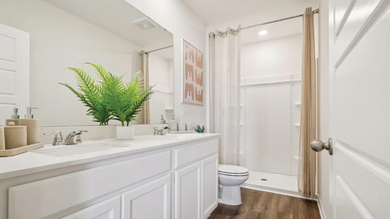 Primary bathroom with dual vanity sink and walk in shower