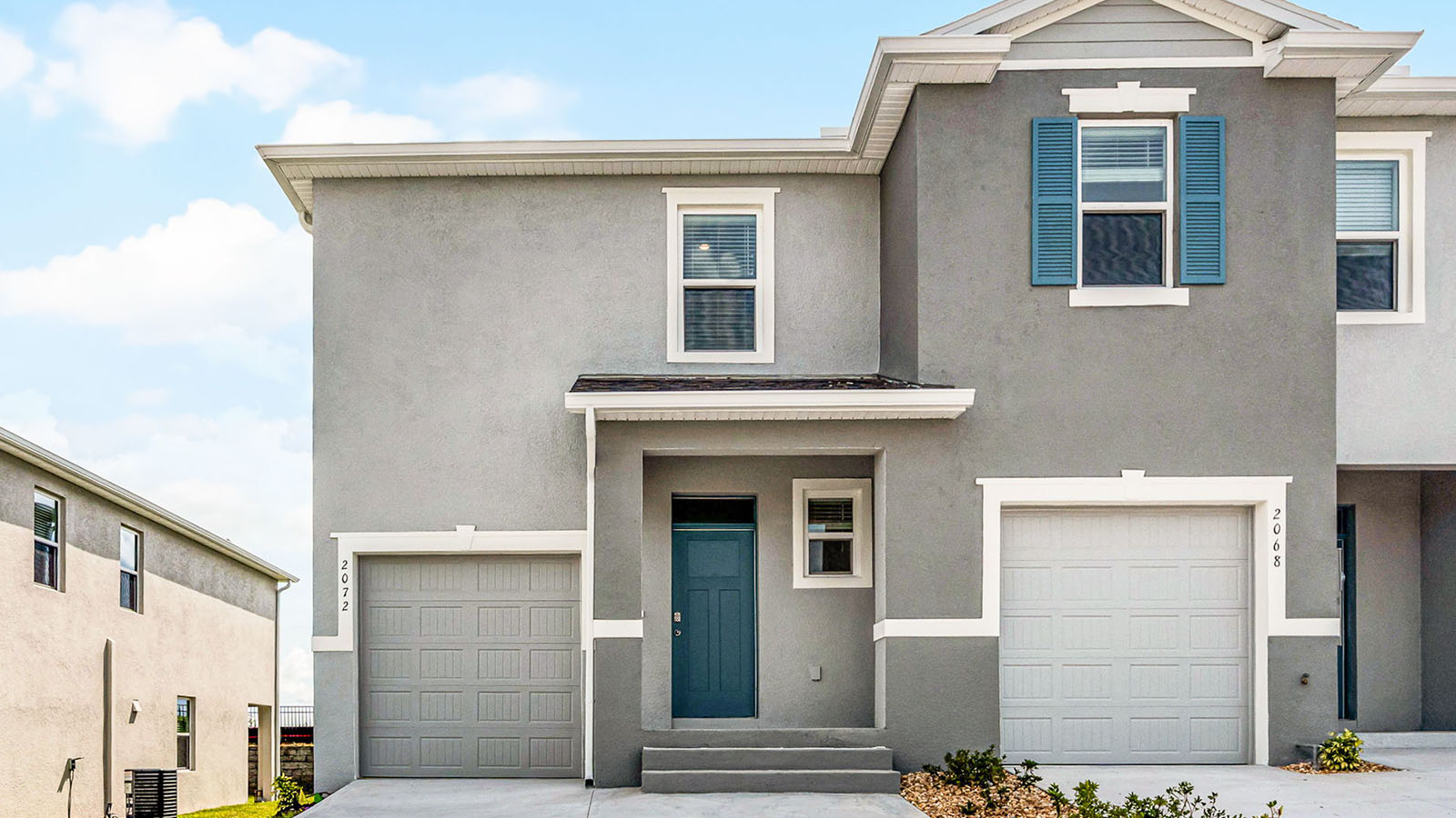 Exterior image of two story townhome and single car garage