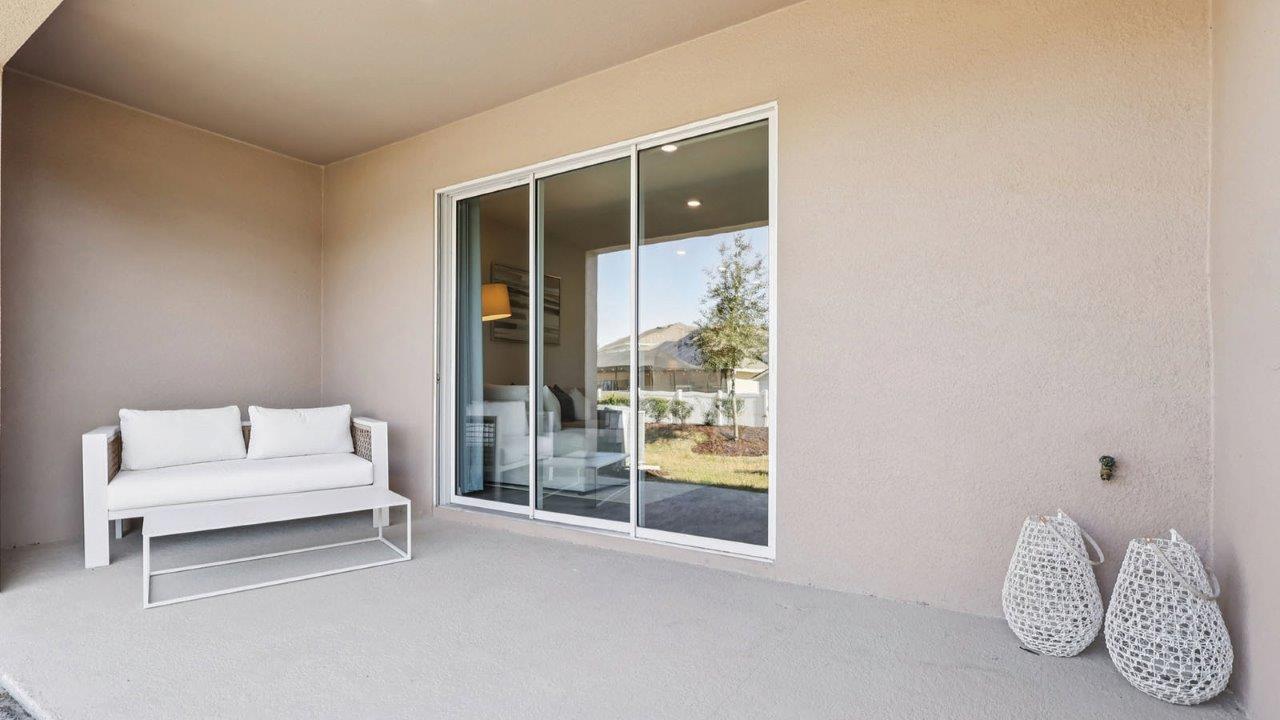 Covered patio with couch and large sliding glass doors