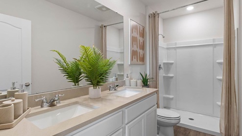 Primary bathroom with double vanity sinks and walk in shower