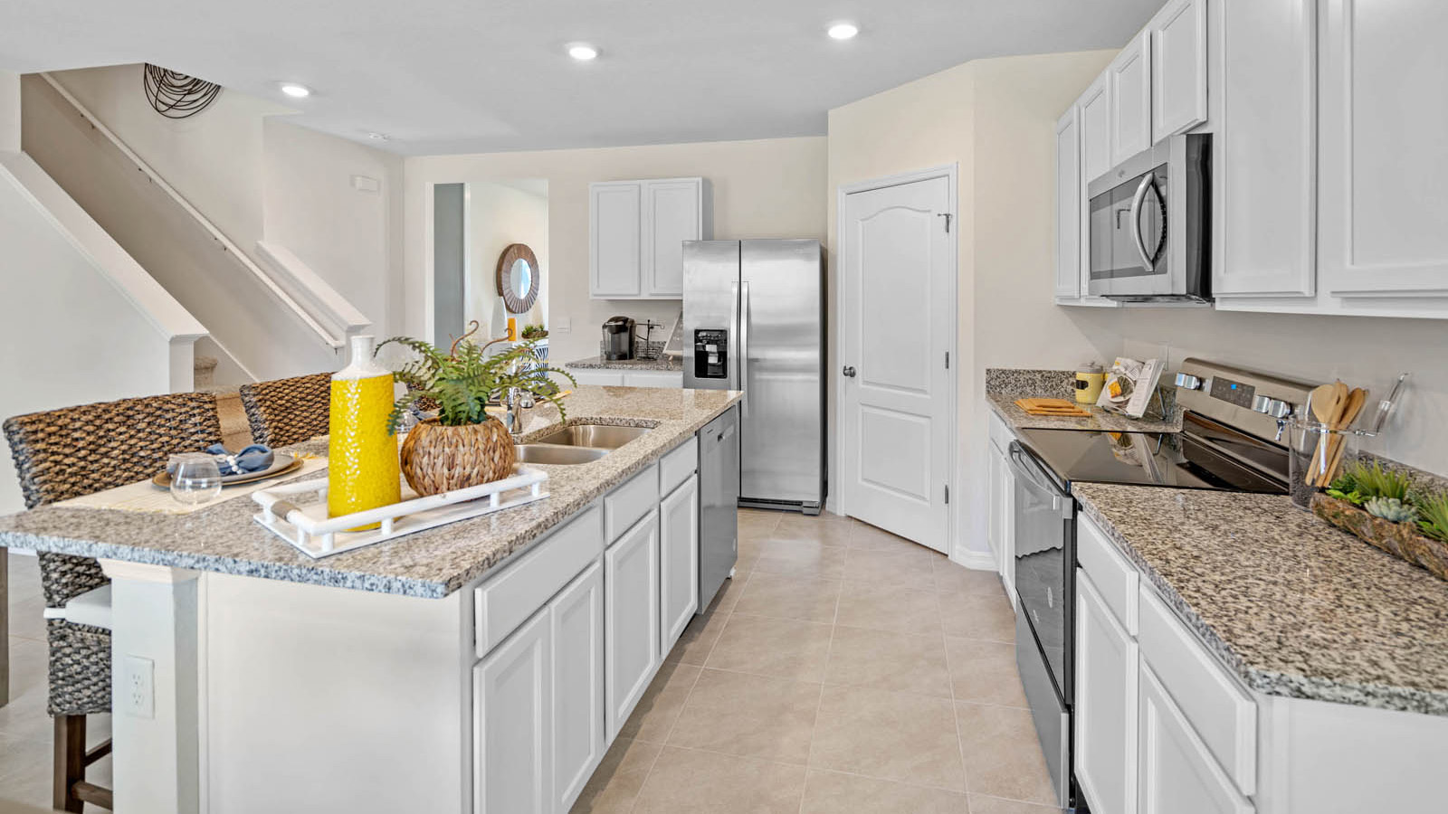 Kitchen island with sink adjacent to the stove and microwave