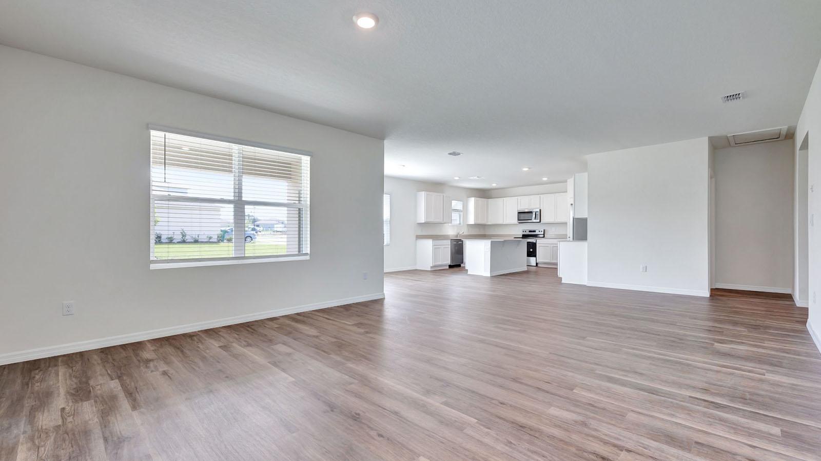 Living room with view of the kitchen and half bath entrance