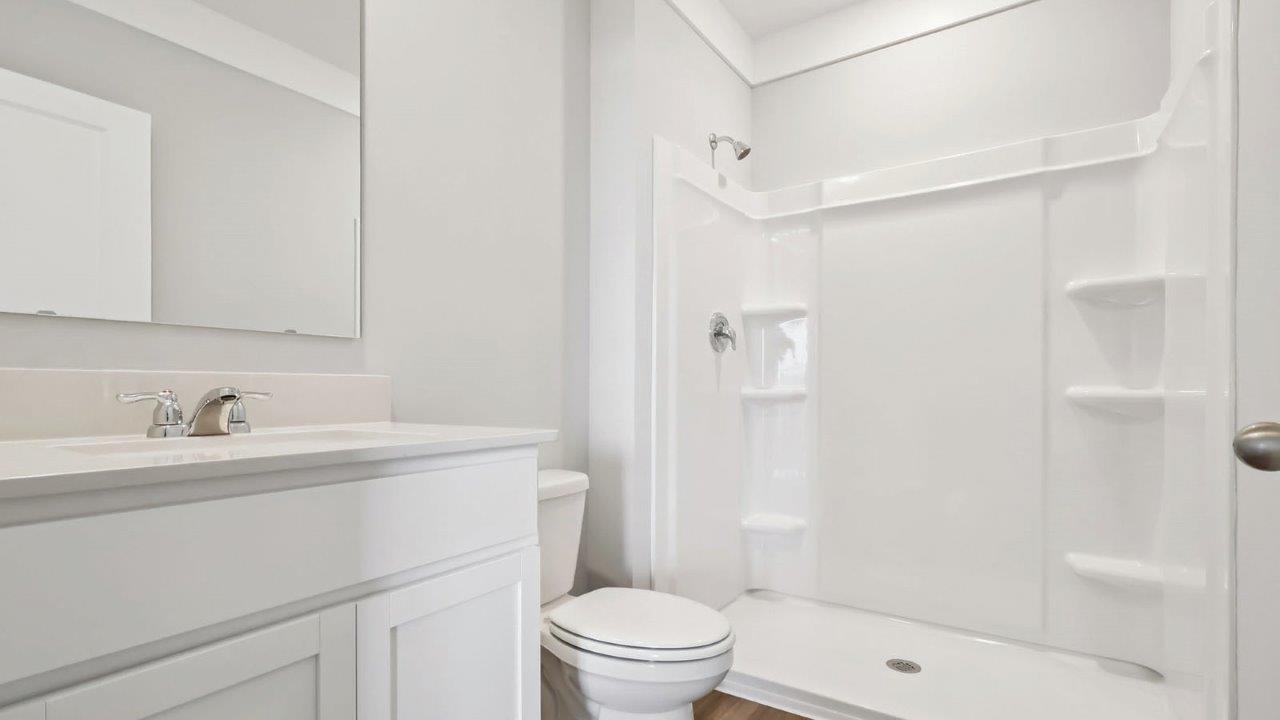 Bathroom with walk in shower and white cabinets