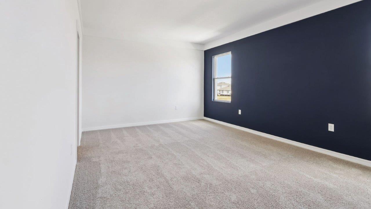 Spacious primary bedroom with windows