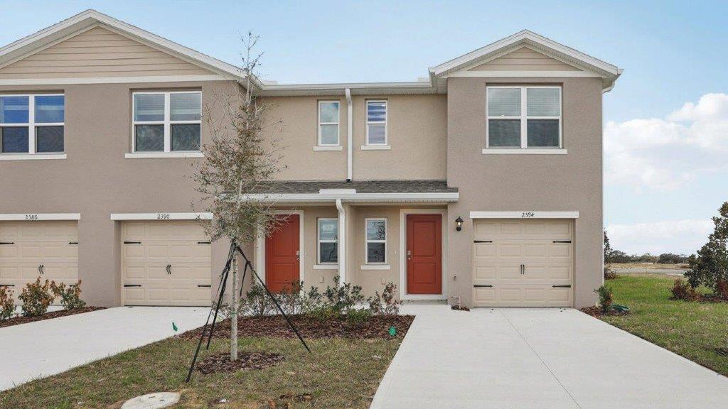 Exterior of a townhome with a single car garage and white exterior