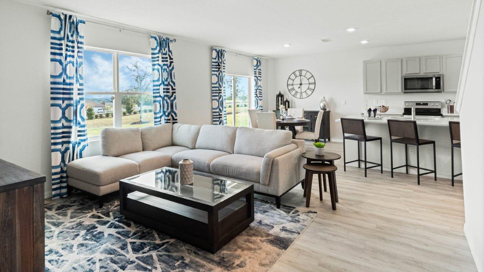 Living room view of kitchen and dining nook with sliding glass doors
