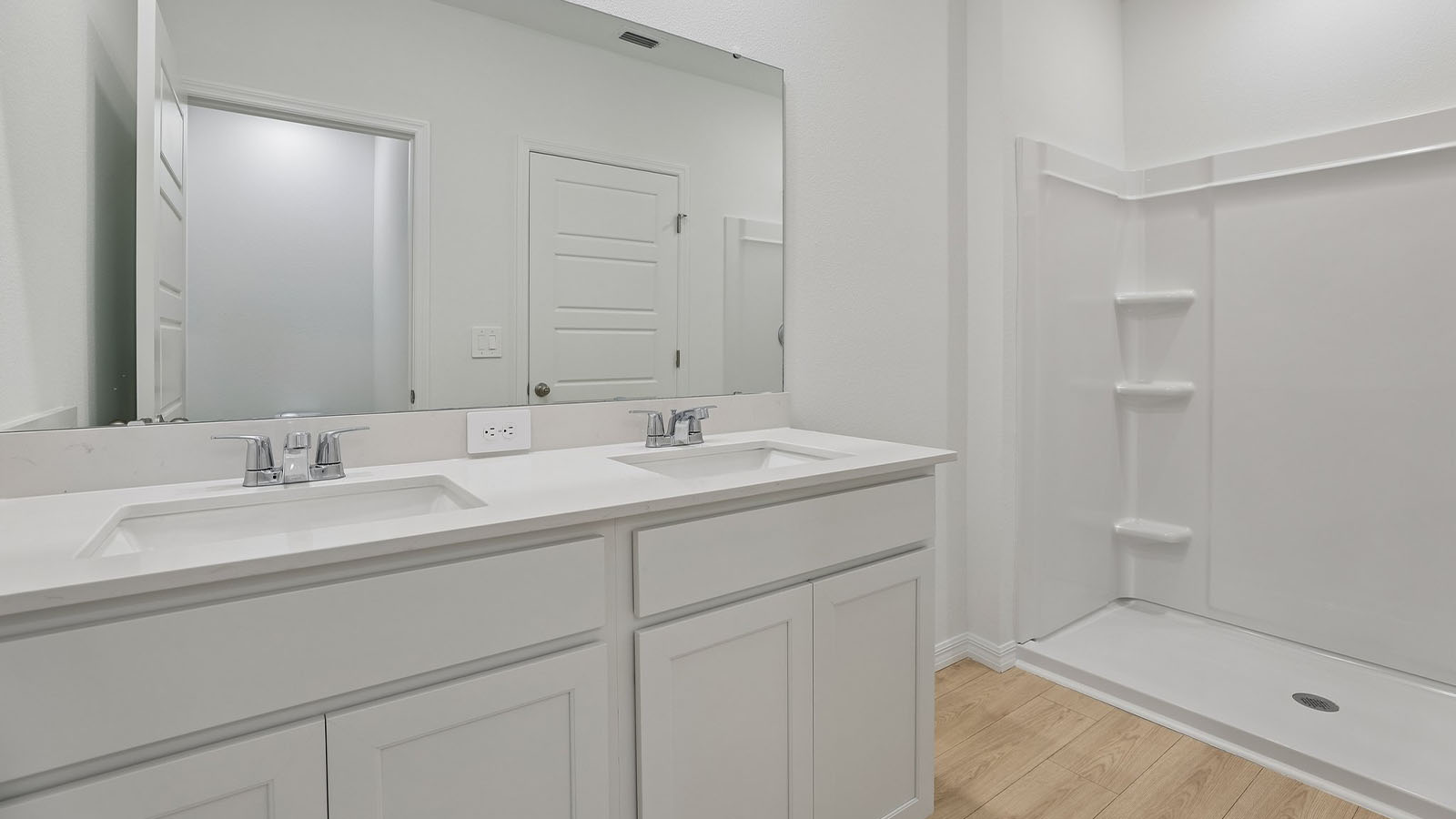 Primary bathroom with double vanity and walk in shower