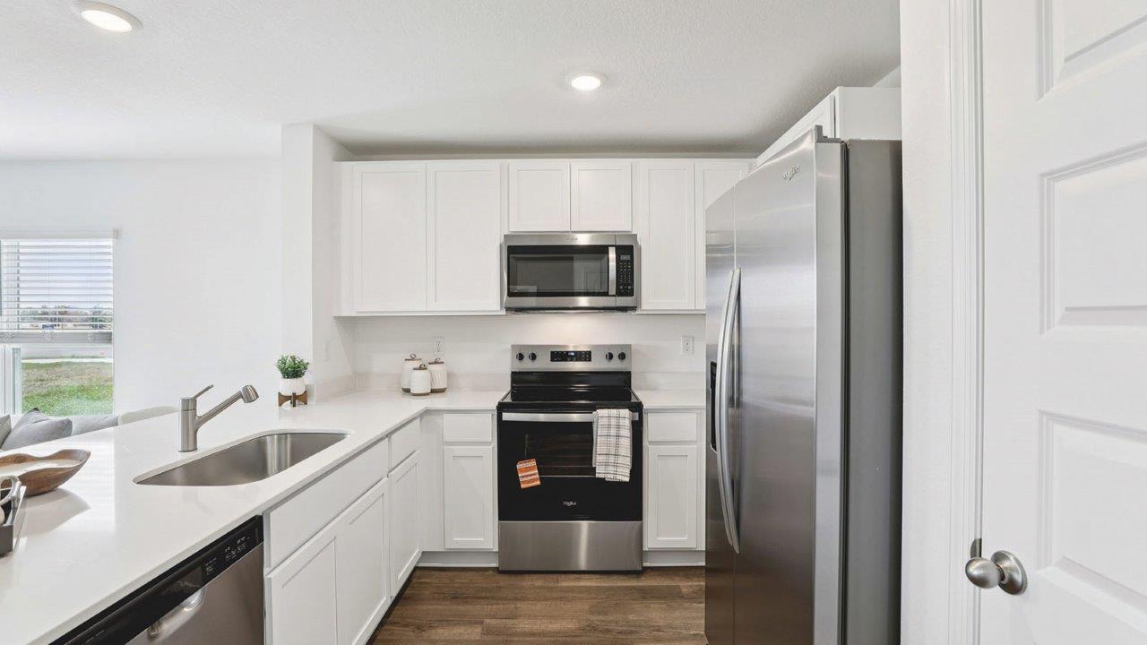 Kitchen with island and barstools with view to entryway
