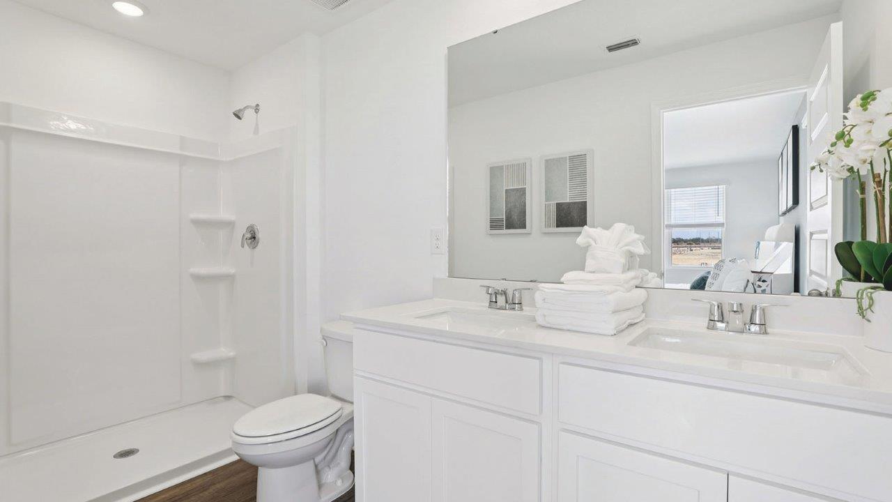 Primary bathroom attached bathroom with double vanity sinks and walk in shower