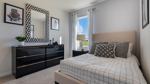Guest bedroom with vanity and full sized bed