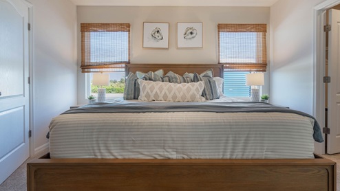 Close up of the bed with two windows in the back