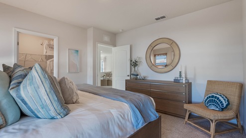 Primary bedroom with carpet and vanity