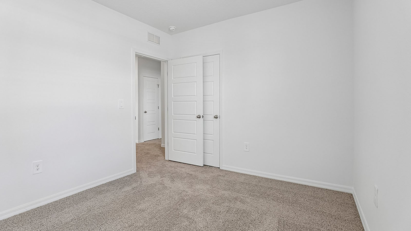 Guest bedroom with built in closet and carpet flooring