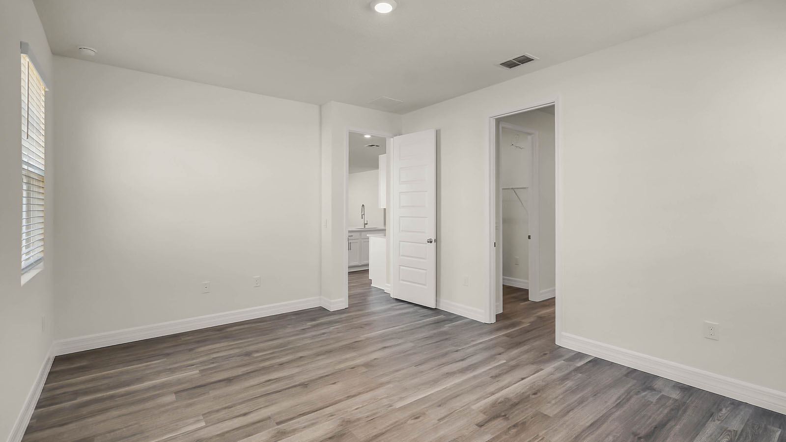primary bedroom with door to primary bathroom