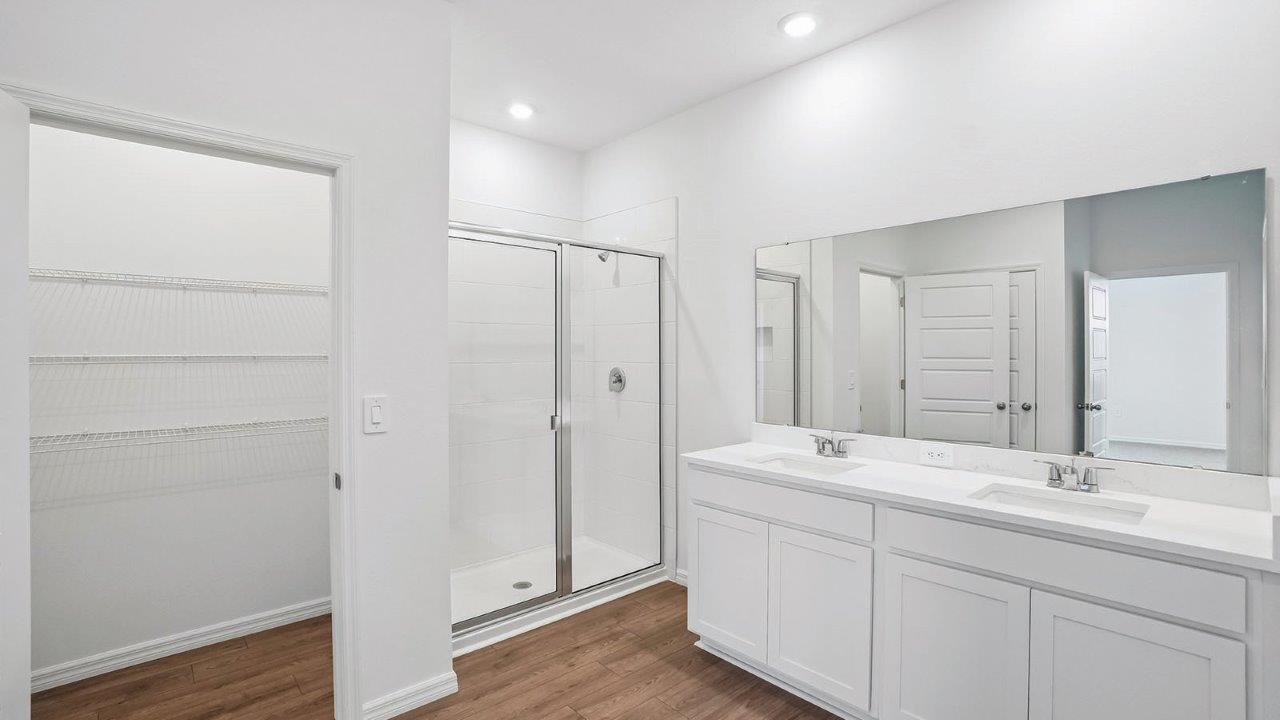 Primary bathroom with dual vanity sink and walk in shower