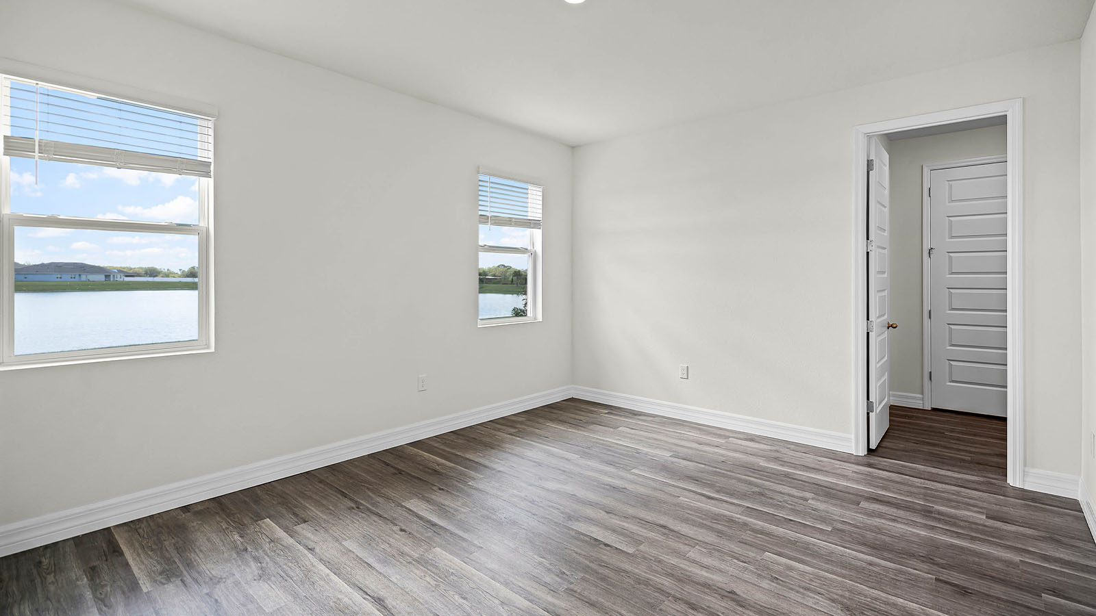 primary bedroom with windows and luxury vinyl planks