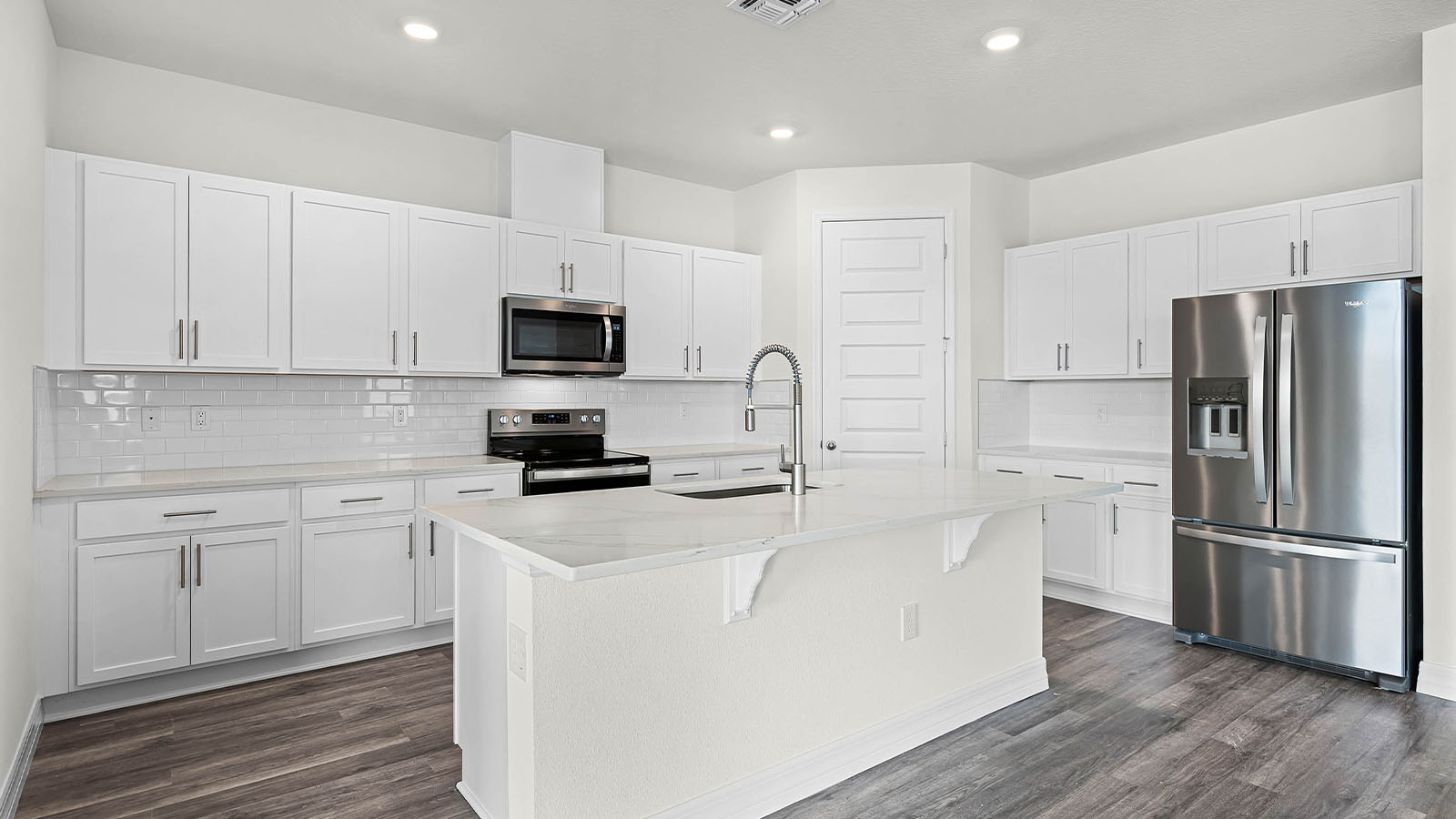 kitchen with large island, pantry and stainless steel appliances