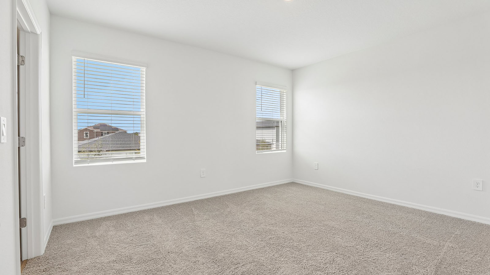 Primary bedroom with carpet and windows