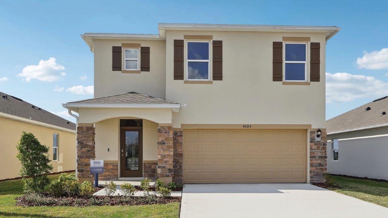 Front view of single-family two-story home with two-car garage with shutters and stone accents