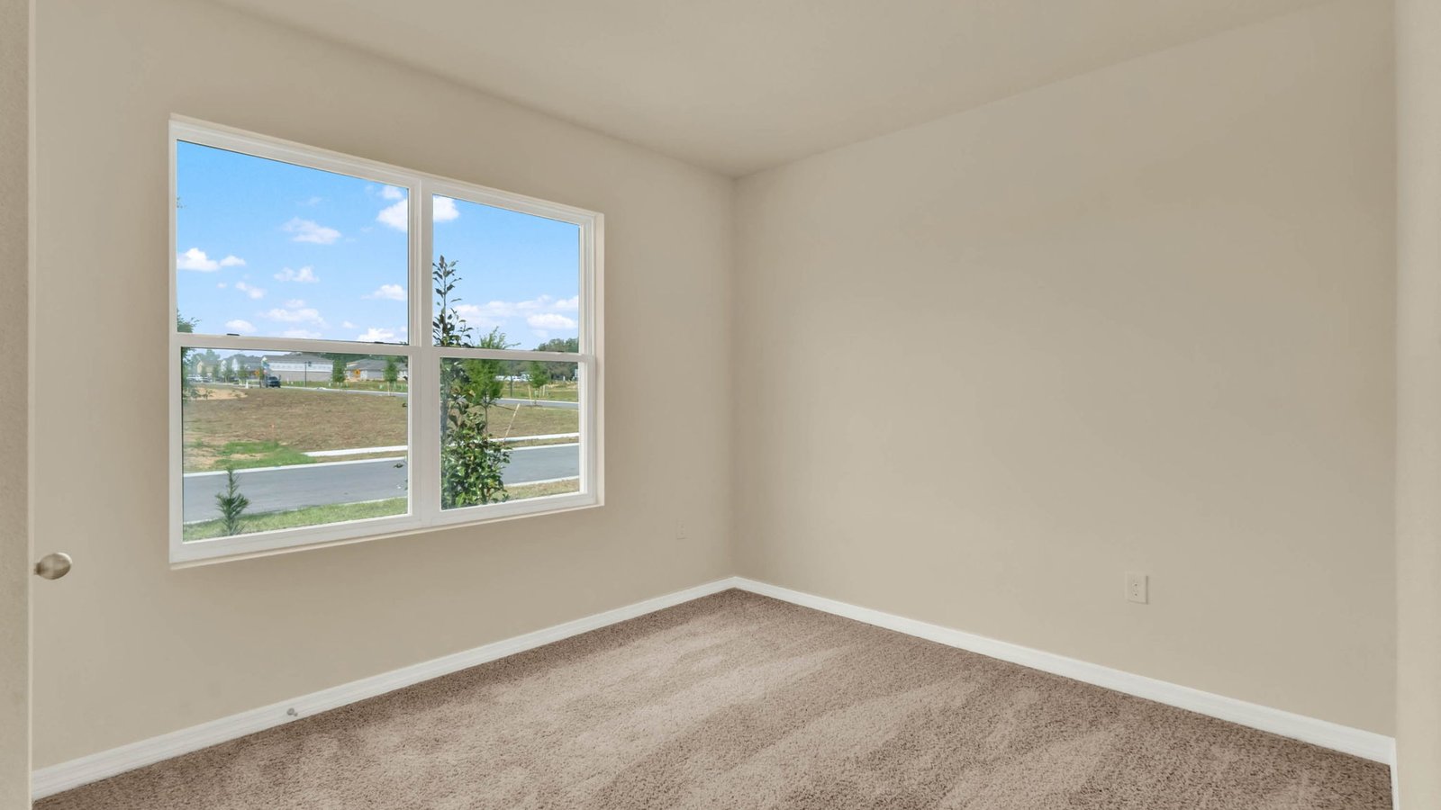 Guest bedroom with large window and carpet
