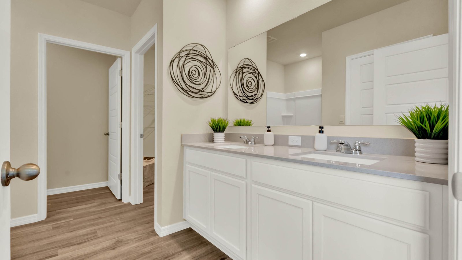 Primary bathroom with double vanity sink, quartz counter tops and walk in closet