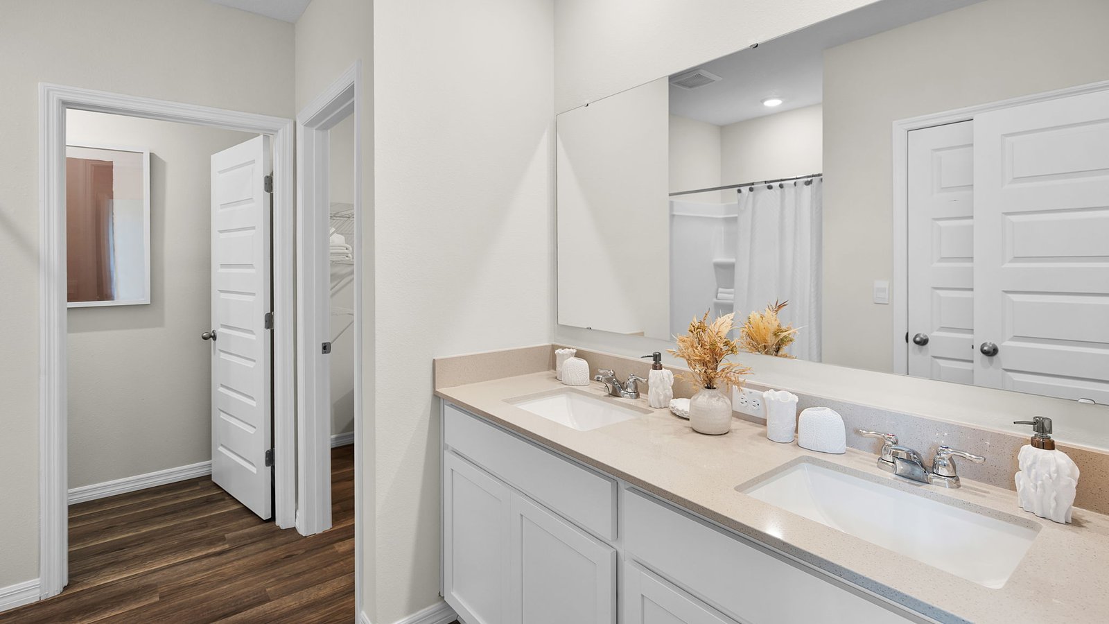 Primary bathroom with double vanity sink, quartz counter tops and walk in closet