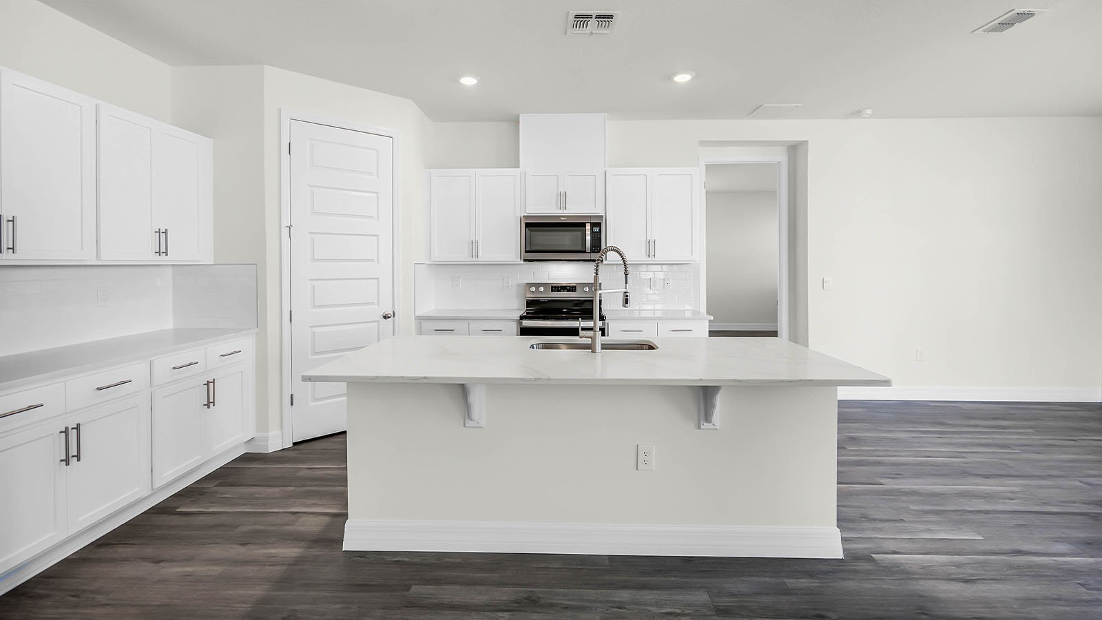 kitchen with large island, pantry and stainless steel appliances