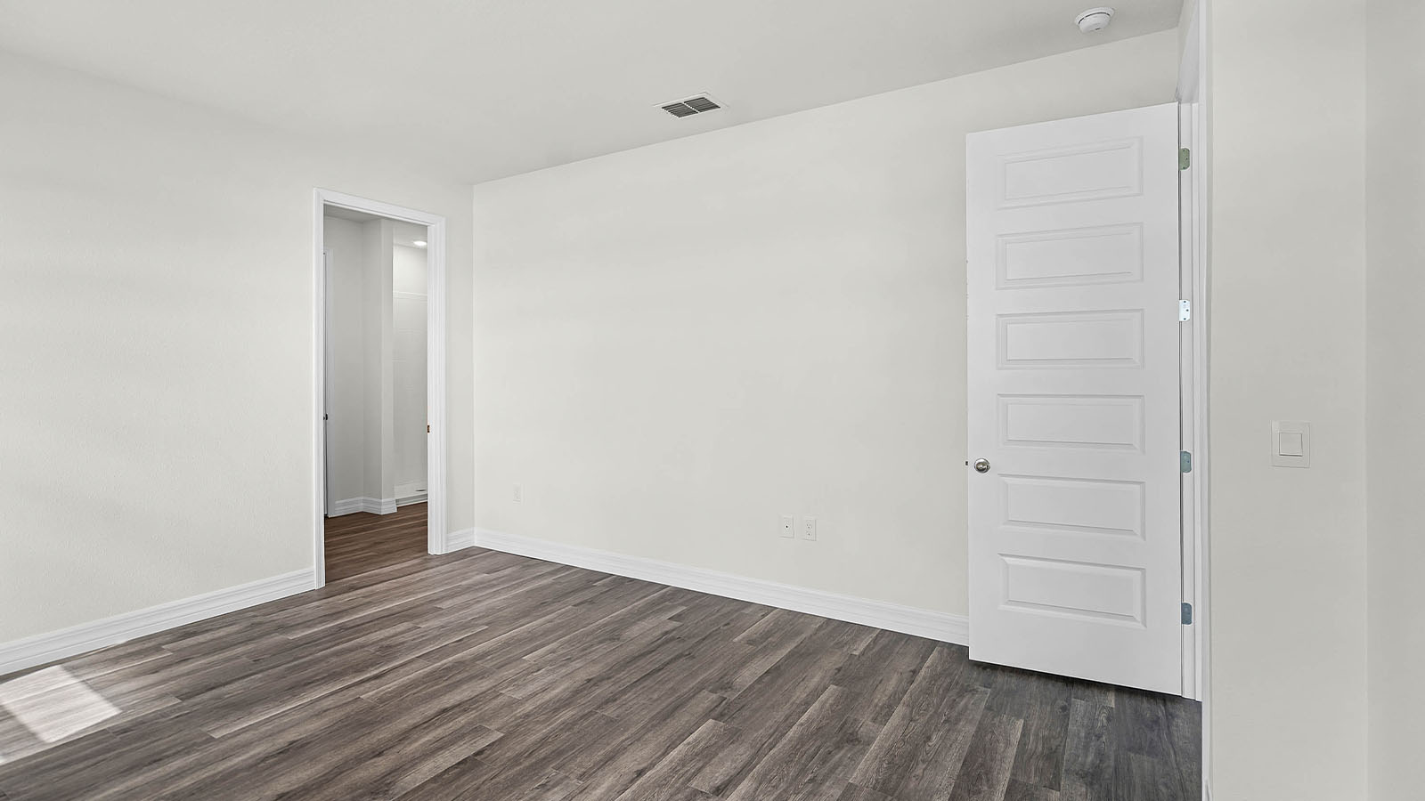primary bedroom with door to primary bathroom