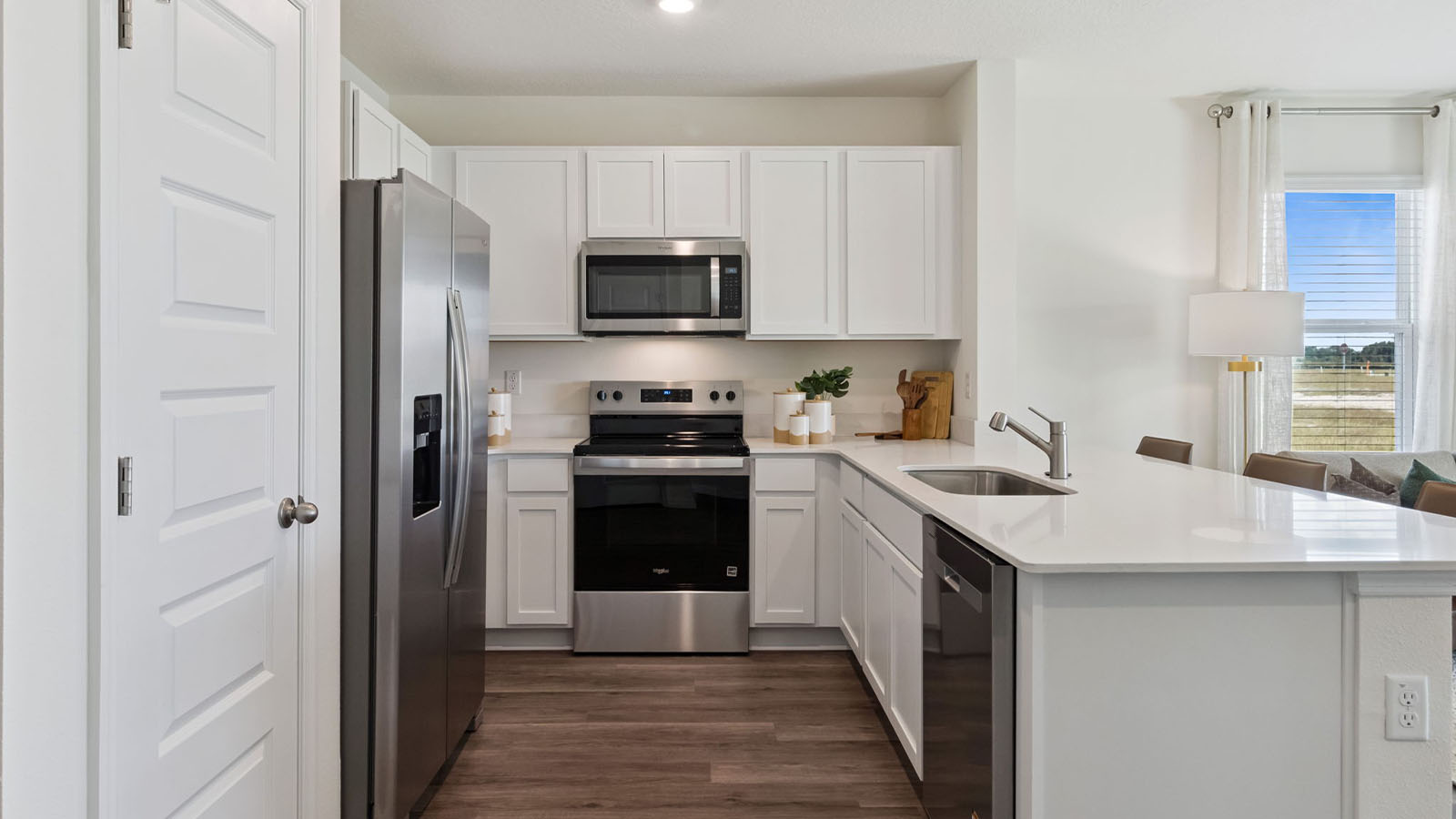 Kitchen with island peninsula and stainless steel appliances