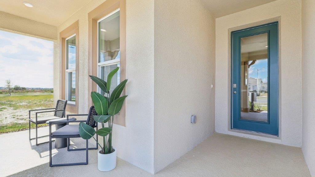 front porch with two chairs and plant