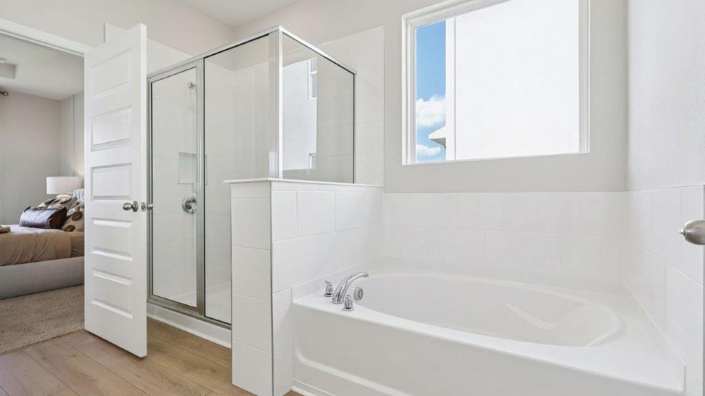 primary bathroom with tub and walk in shower