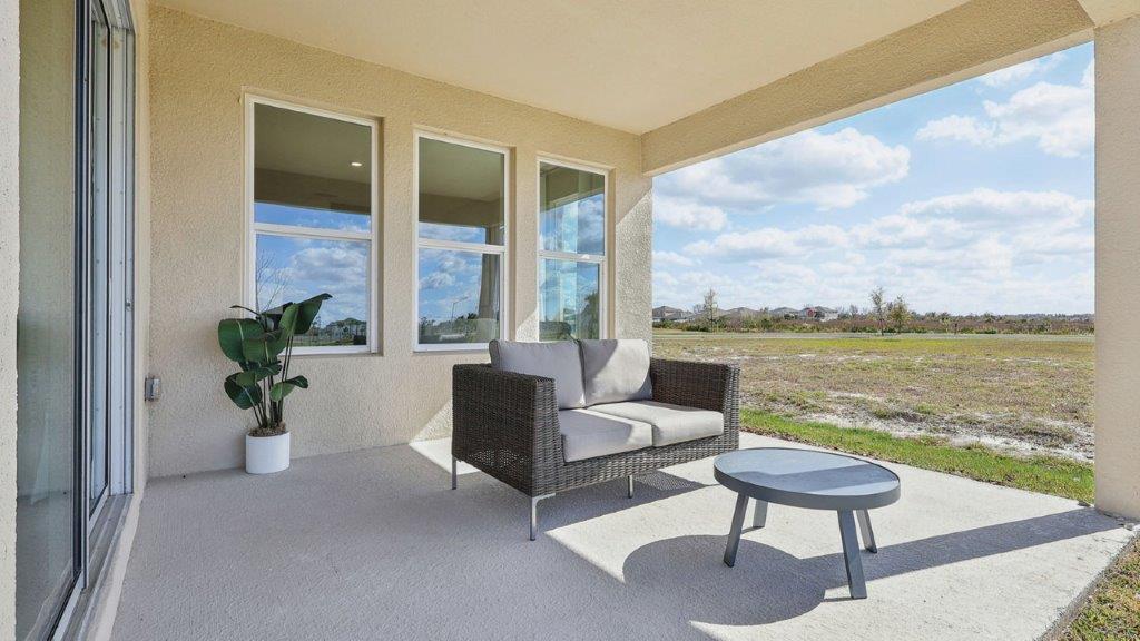 covered rear patio with sectional and table