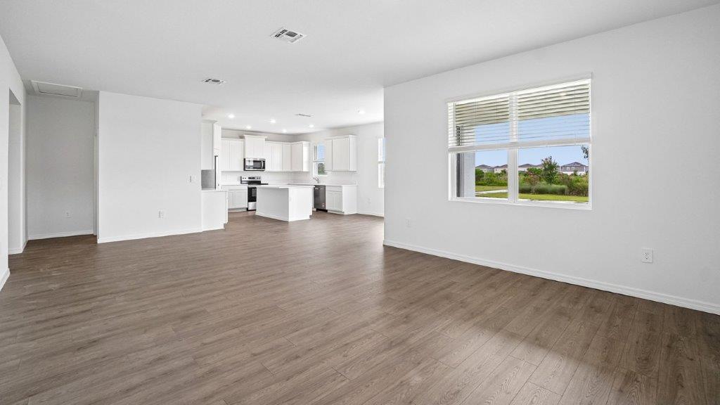 Living room with Luxury Vinyl Plank Flooring throughout adjacent to the kitchen