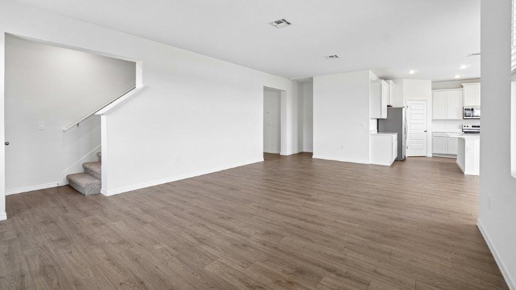Living room with Luxury Vinyl Plank Flooring throughout adjacent to the stairs