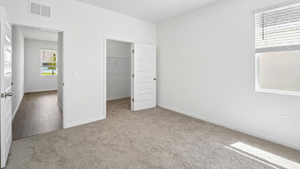 Downstairs bedroom with carpet with a closet