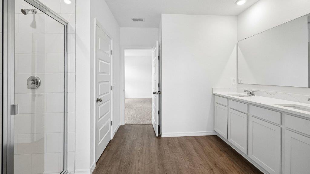 Primary bathroom with luxury vinyl planks and double sink vanity