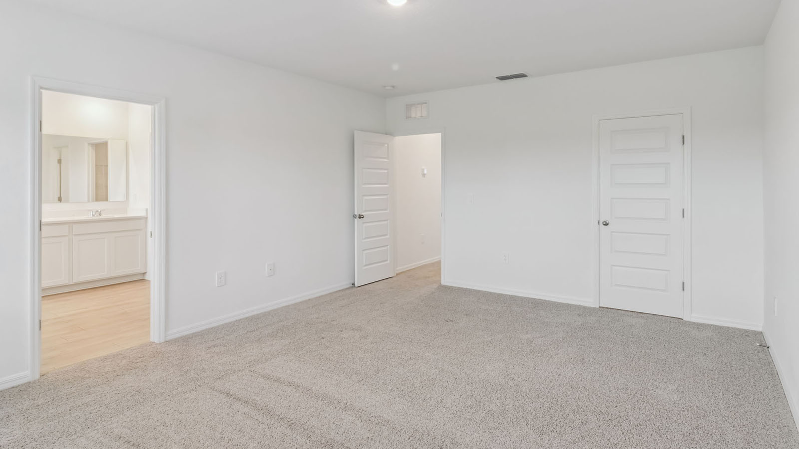 Primary bedroom with carpet and ensuite bathroom