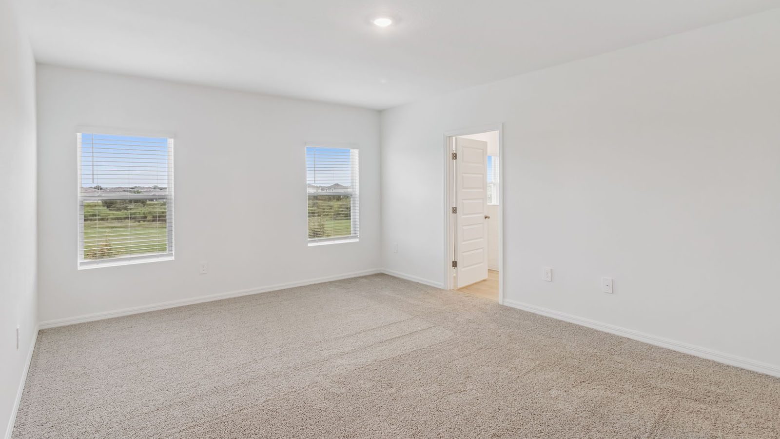 Primary bedroom with carpet and windows