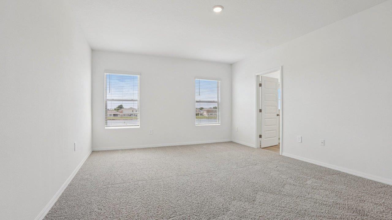 Primary bedroom with a walk in closet