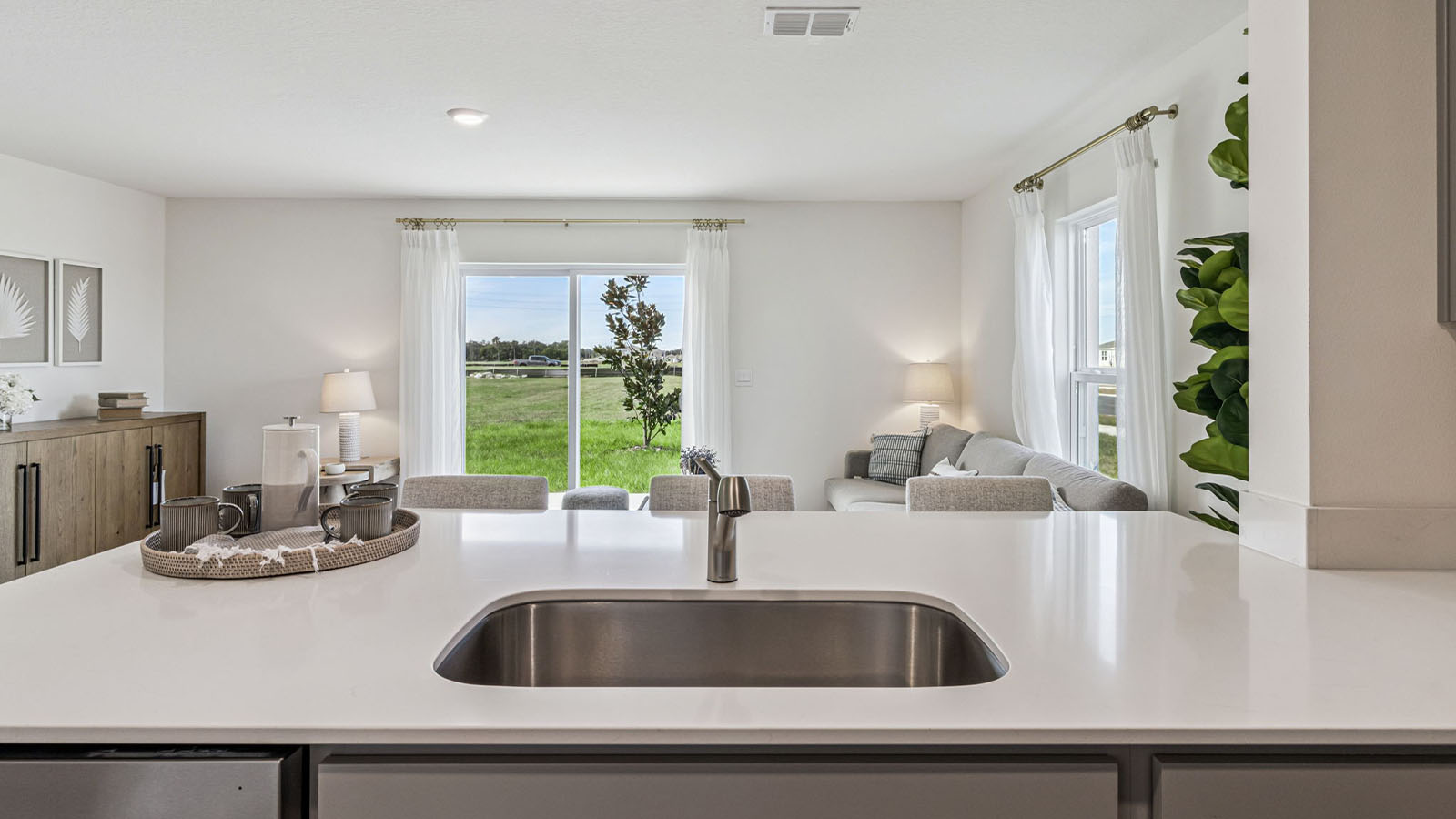 Kitchen with island and barstools with view to entryway